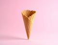 Empty wafer ice cream cone on pale pink background Royalty Free Stock Photo