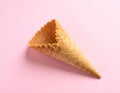 Empty wafer ice cream cone on pale pink background Royalty Free Stock Photo