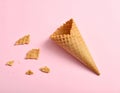 Empty wafer ice cream cone on pale pink background Royalty Free Stock Photo