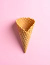 Empty wafer ice cream cone on pale pink background Royalty Free Stock Photo