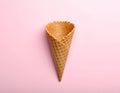 Empty wafer ice cream cone on pale pink background Royalty Free Stock Photo