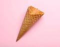 Empty wafer ice cream cone on pale pink background Royalty Free Stock Photo