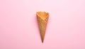 Empty wafer ice cream cone on pale pink background Royalty Free Stock Photo