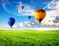 Dream world. Hot air balloons in sky with clouds over green meadow Royalty Free Stock Photo