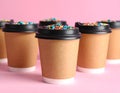 Delicious edible biscuit coffee cups decorated with sprinkles on color background Royalty Free Stock Photo