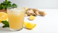 Glass of tasty ginger ale with ice cube and ingredients on white table, closeup Royalty Free Stock Photo