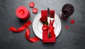 Romantic place setting with candles and red ribbon on dark gray textured table, flat lay Royalty Free Stock Photo