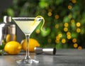 Glass of Lemon Drop Martini cocktail with zest on table against blurred background Royalty Free Stock Photo