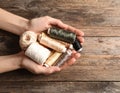 Woman holding clews of threads on wooden background, top view. Space for text Royalty Free Stock Photo
