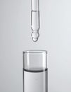 Dripping liquid from pipette into test tube on grey background, closeup Royalty Free Stock Photo