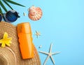 Flat lay composition with sunscreen and beach accessories on light blue background Royalty Free Stock Photo