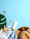 Flat lay composition with sunscreen and beach accessories on light blue background Royalty Free Stock Photo