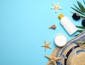 Flat lay composition with sunscreen and beach accessories on light blue background Royalty Free Stock Photo