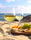 Glasses with white wine and snacks for beach picnic on sandy seashore Royalty Free Stock Photo