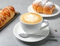 Cup of caramel macchiato and tasty pastry on table Royalty Free Stock Photo