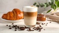 Cup of caramel macchiato and tasty pastry on table Royalty Free Stock Photo