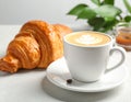 Cup of caramel macchiato and tasty pastry on table Royalty Free Stock Photo
