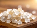 A small pile of translucent, irregularly shaped sugar crystals rests on a wooden surface Royalty Free Stock Photo