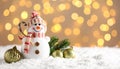 Cute snowman, fire tree branches and balls against fuzzy Christmas lights, bokeh effect Royalty Free Stock Photo