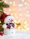 Cute snowman, fire tree branches and balls against fuzzy Christmas lights, bokeh effect Royalty Free Stock Photo