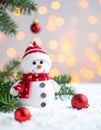 Cute snowman, fire tree branches and balls against fuzzy Christmas lights, bokeh effect Royalty Free Stock Photo