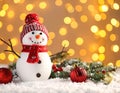 Cute snowman, fire tree branches and balls against fuzzy Christmas lights, bokeh effect Royalty Free Stock Photo