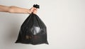 Woman holding full garbage bag on light background, closeup. Space for text Royalty Free Stock Photo