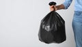 Woman holding full garbage bag on light background, closeup. Space for text Royalty Free Stock Photo
