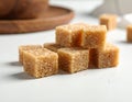 Cubes of brown sugar fill a white ceramic bowl, placed on a white surface. Royalty Free Stock Photo
