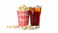 A glass filled with dark soda and ice cubes sits beside a large tub of popcorn. Royalty Free Stock Photo