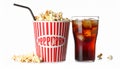 A glass filled with dark soda and ice cubes sits beside a large tub of popcorn. Royalty Free Stock Photo