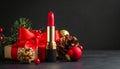 Red lipstick stands upright against a backdrop of wrapped gifts adorned with red ribbons. Royalty Free Stock Photo