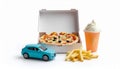 A model car in blue sits next to a pizza box, which is open to reveal a pizza topped with olives and cheese. Royalty Free Stock Photo