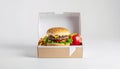 Burger meal in a cardboard box, featuring a sesame seed bun burger with lettuce, cheese, and tomato. Royalty Free Stock Photo