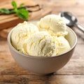 Bowl and spoon with tasty vanilla ice cream on table Royalty Free Stock Photo
