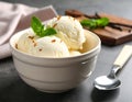 Bowl and spoon with tasty vanilla ice cream on table Royalty Free Stock Photo