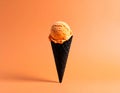 Halloween ice cream cone with orange scoop on pastel background Royalty Free Stock Photo