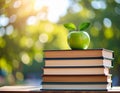 Green apple on a stack of books with nature background Royalty Free Stock Photo