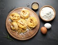 Board with homemade pasta, flour and ingredients on dark table, flat lay Royalty Free Stock Photo