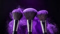 Makeup brushes with purple eye shadow on black background, closeup. Royalty Free Stock Photo
