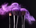 Makeup brushes with purple eye shadow on black background, closeup. Royalty Free Stock Photo