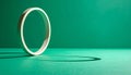 Minimalist light circular ring standing vertically on teal monochromatic background with shadow Royalty Free Stock Photo