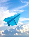 Light blue paper plane flying in sky with clouds with clouds Royalty Free Stock Photo