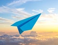 Light blue paper plane flying in sky with clouds with clouds Royalty Free Stock Photo