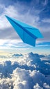 Light blue paper plane flying in sky with clouds with clouds Royalty Free Stock Photo