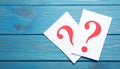 Paper cards with question mark on blue wooden background, top view. Space for text Royalty Free Stock Photo
