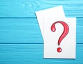 Paper cards with question mark on blue wooden background, top view. Space for text Royalty Free Stock Photo