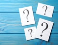 Paper cards with question mark on blue wooden background, top view. Space for text Royalty Free Stock Photo