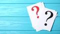Paper cards with question mark on blue wooden background, top view. Space for text Royalty Free Stock Photo