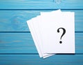Paper cards with question mark on blue wooden background, top view. Space for text Royalty Free Stock Photo